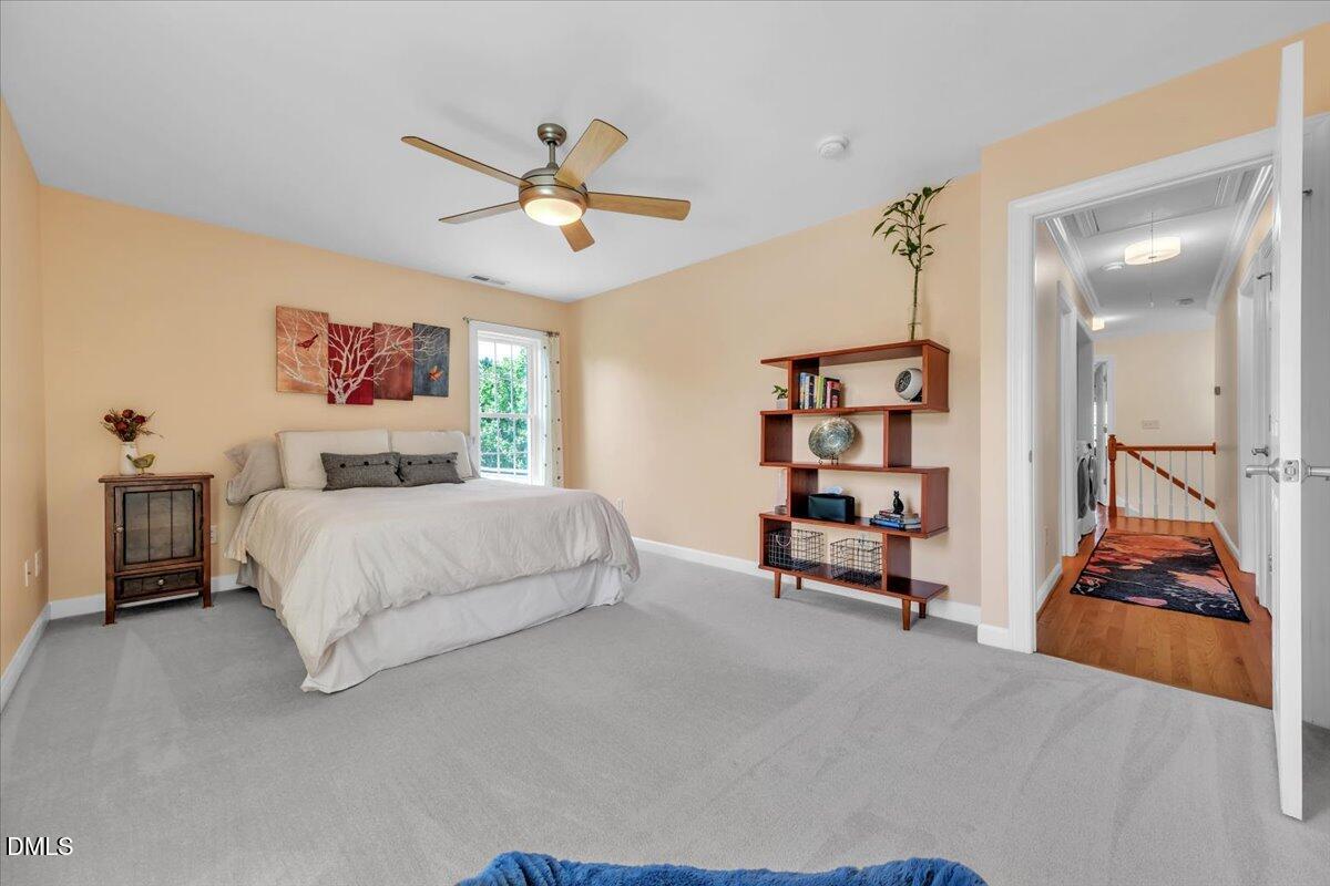 2908 Oak Bridge Drive Raleigh, NC 27610 - Photo 34 of 47 a bedroom with a bed and a chandelier