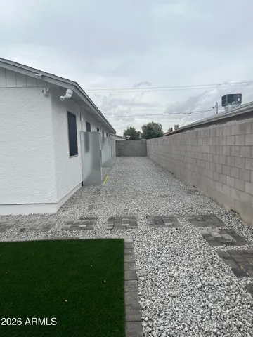 a view of a dry yard with wooden fence