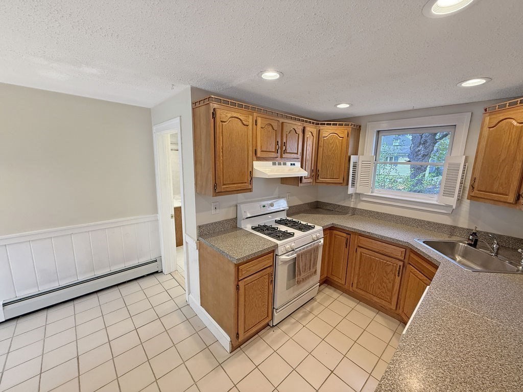 52 Littleton Road, Unit 1 Chelmsford, MA 01824 - Photo 1 of 40 a kitchen with stainless steel appliances granite countertop a stove a sink and a refrigerator