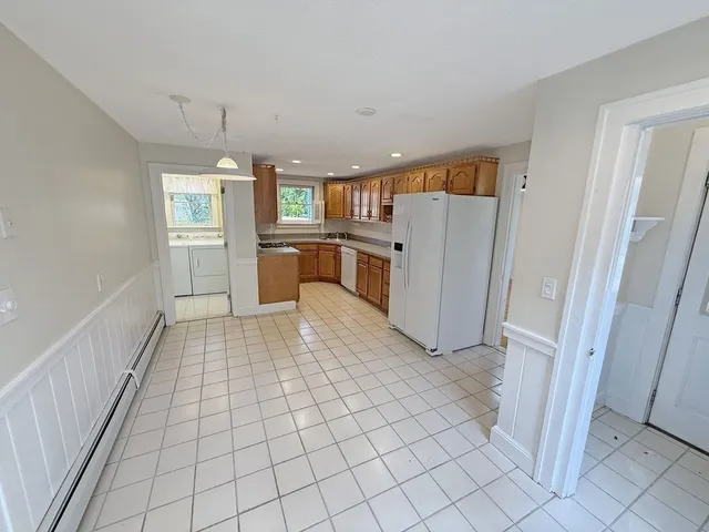 a view of a kitchen with fridge and front door