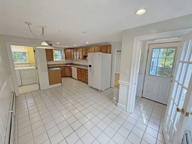 a kitchen with a refrigerator and white cabinets