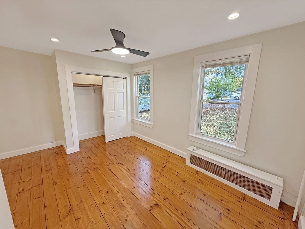 52 Littleton Road, Unit 1 Chelmsford, MA 01824 - Photo 23 of 40 a view of an empty room with wooden floor and a window