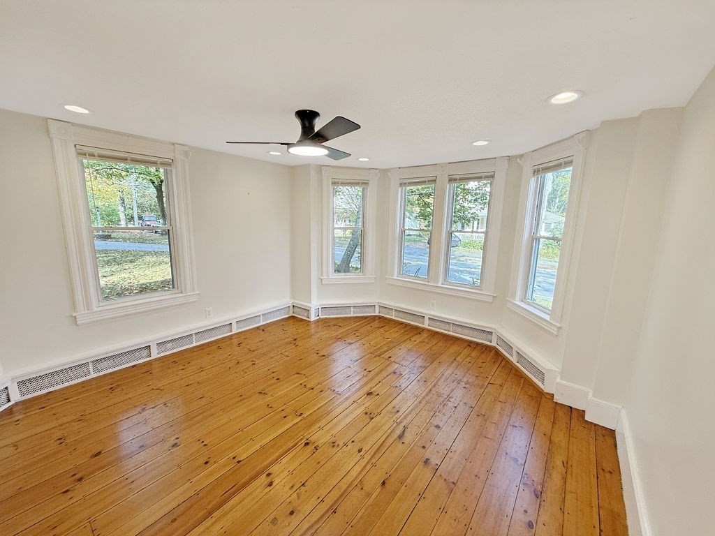 52 Littleton Road, Unit 1 Chelmsford, MA 01824 - Photo 27 of 40 a view of an empty room with a window and wooden floor