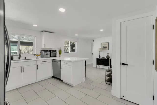 a kitchen with a sink a refrigerator and cabinets