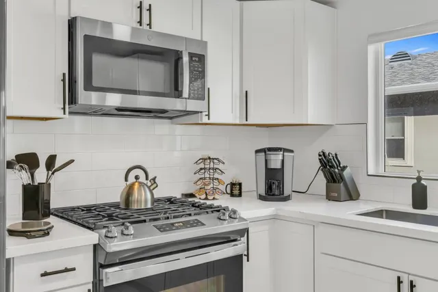 a view of a refrigerator in kitchen and white cabinets
