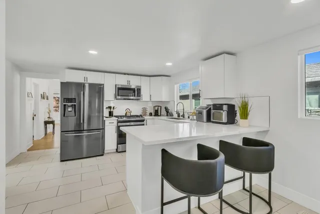 a kitchen with a sink and chairs