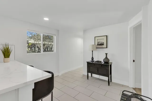 a bedroom with a bed and a potted plant on the dresser
