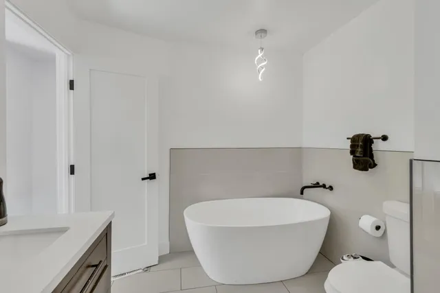 a view of a hallway with wooden floor and a bathroom sink