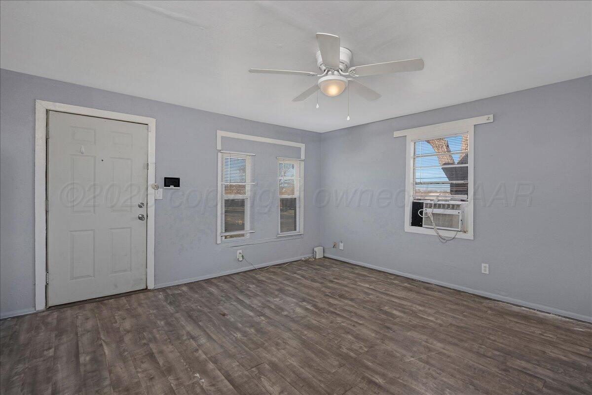 1108 North Madison Street Amarillo, TX 79107 - Photo 6 of 22 a view of an empty room with wooden floor and a window