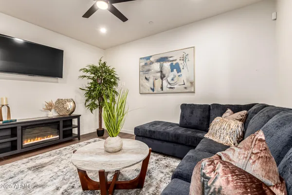 a living room with furniture a flat screen tv and a fireplace