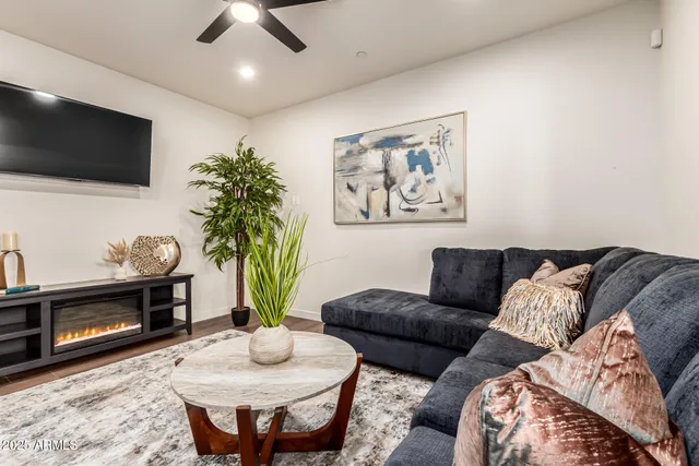 a living room with furniture a flat screen tv and a fireplace