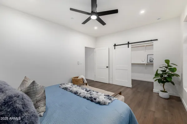 a bedroom with a bed a couch and a potted plant