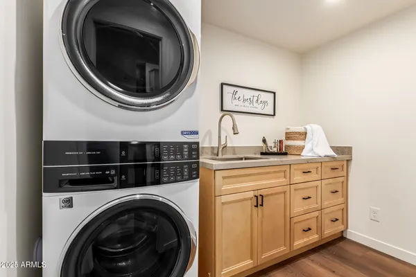 a kitchen with a sink and a stove with wooden floor