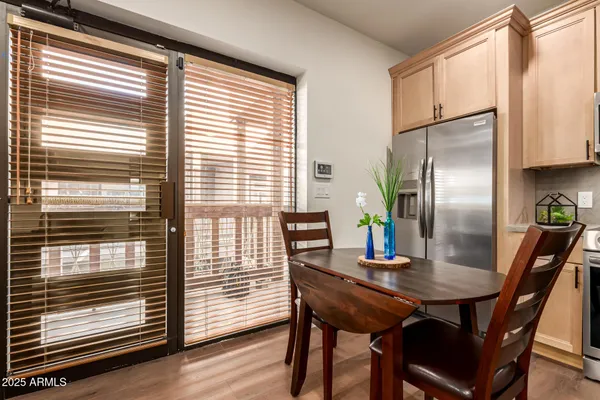 a kitchen with stainless steel appliances a stove a sink a refrigerator and white cabinets