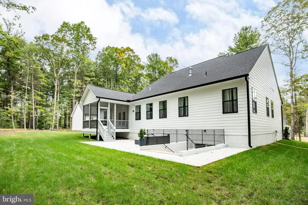 a front view of house with a garden and trees
