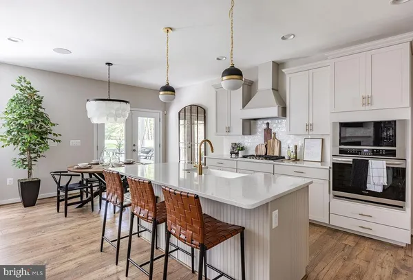 a kitchen with stainless steel appliances granite countertop a kitchen island a stove a table and chairs