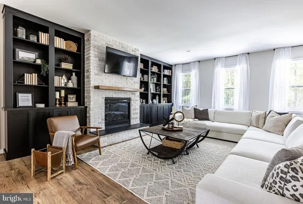 a living room with furniture fireplace and a large window