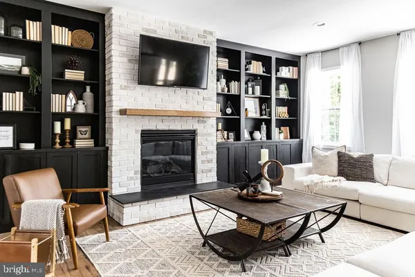 a living room with furniture a bookshelf and a fireplace