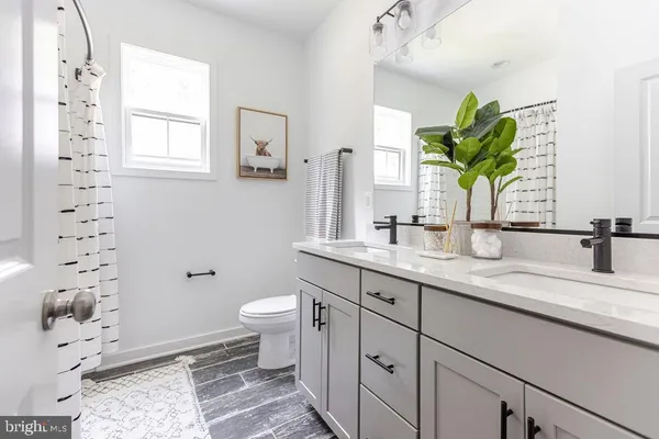 a bathroom with a granite countertop sink a toilet and a mirror