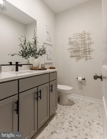 a bathroom with a granite countertop sink a toilet and a mirror