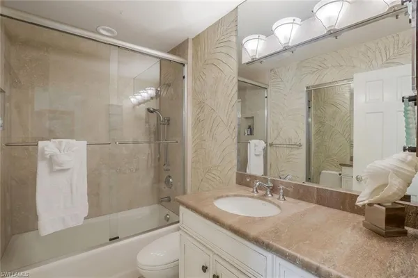 a bathroom with a granite countertop sink toilet and shower
