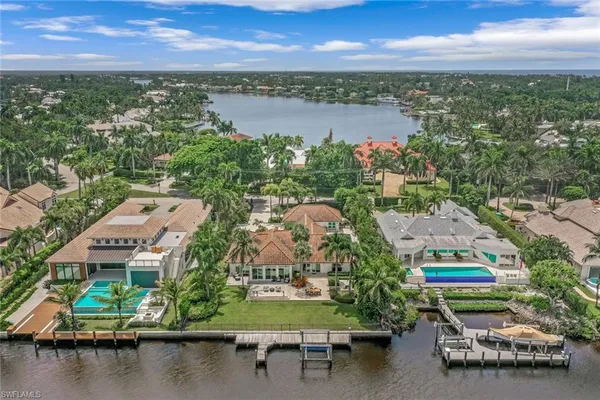 an aerial view of residential houses with outdoor space and lake view