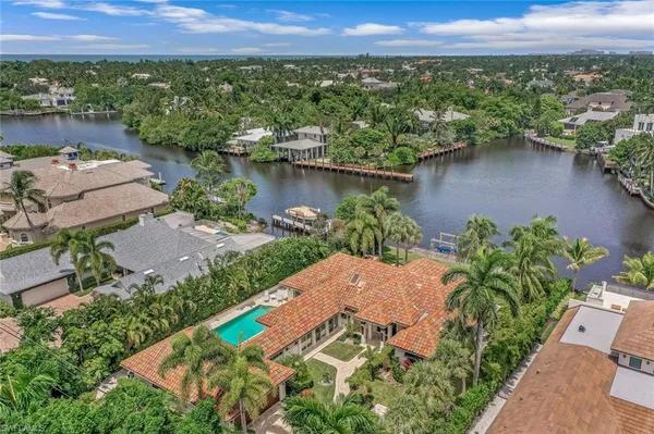 an aerial view of a house with a garden and lake view