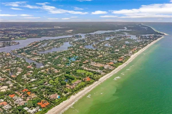 an aerial view of residential houses with outdoor space and ocean view