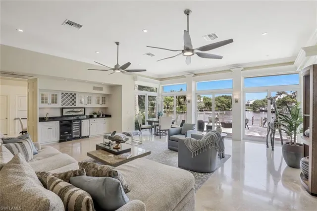 a living room with furniture ceiling fan and a large window
