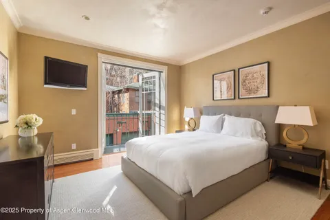 a bedroom with a bed and a lamp on dresser