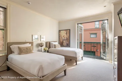 a bedroom with two beds and a large window