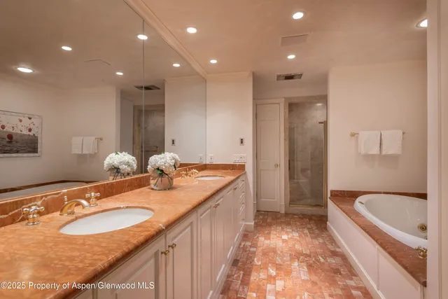 a bathroom with a granite countertop sink a toilet a mirror and bathtub