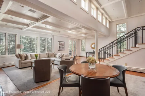 a dining room with furniture a rug and a chandelier