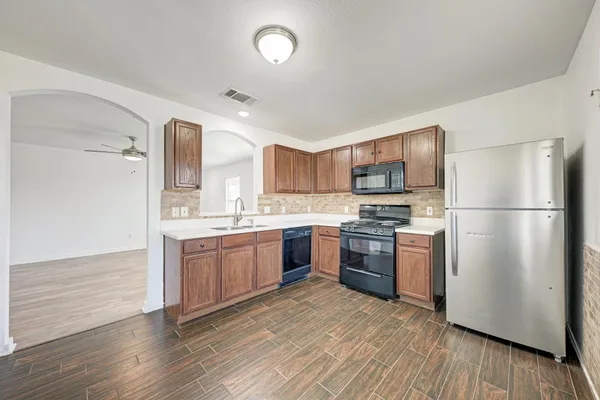 a kitchen with stainless steel appliances granite countertop a refrigerator stove and sink