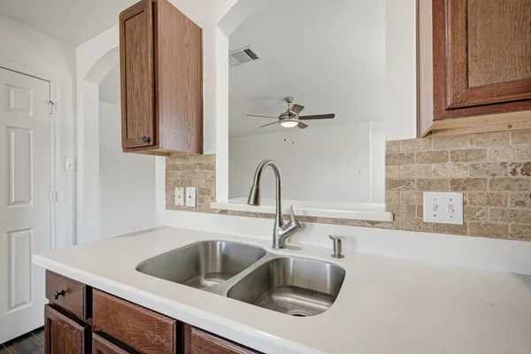 a kitchen with a sink and a microwave with cabinets
