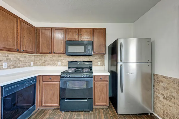 a kitchen with cabinets stainless steel appliances and a counter space