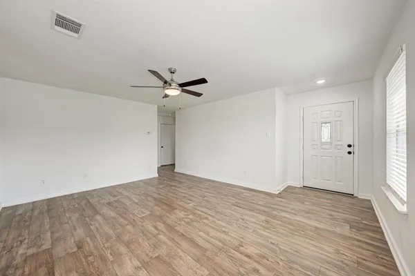 a view of an empty room and wooden floor