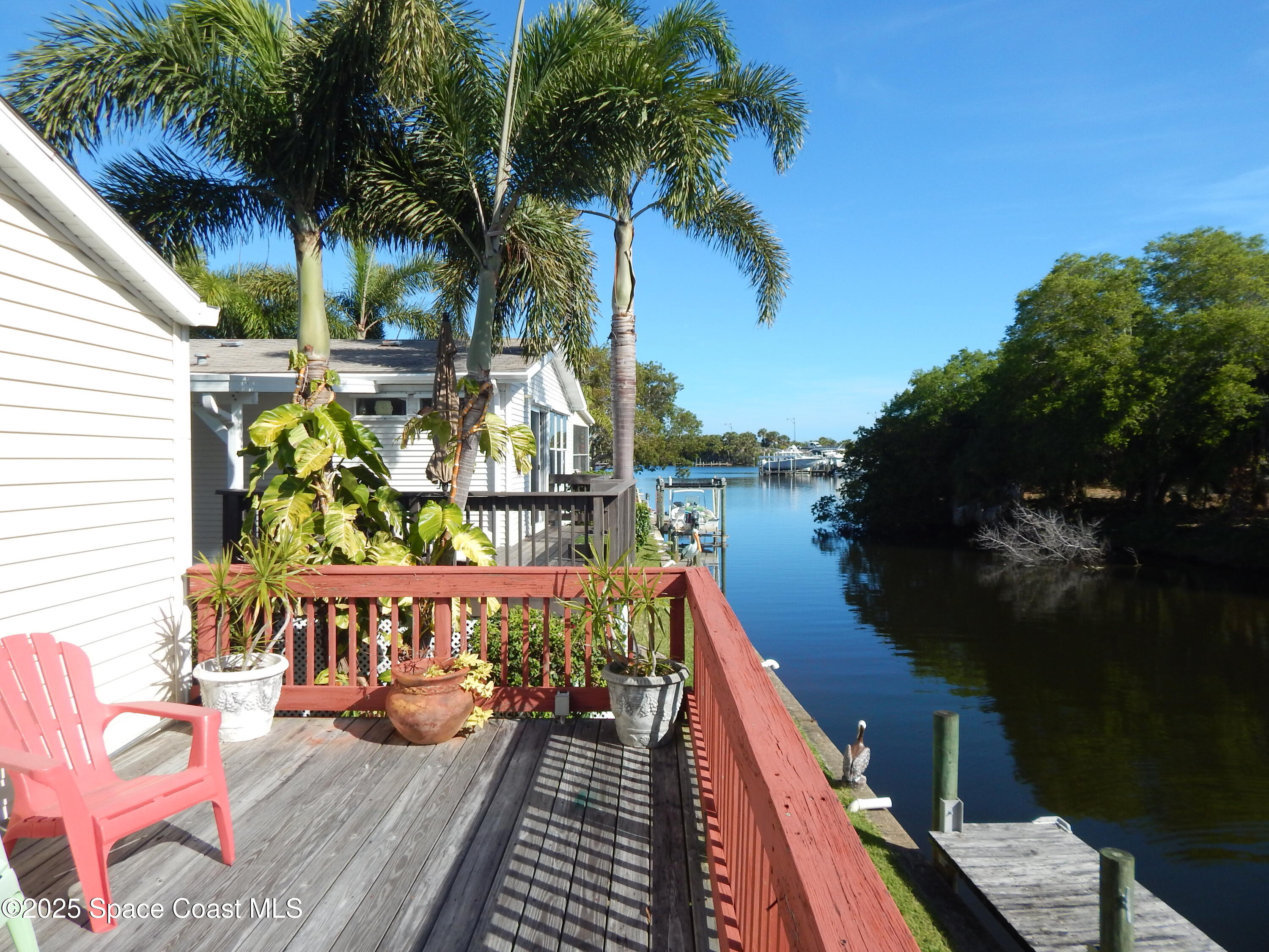 3016 Indian River Drive Northeast Palm Bay, FL 32905 - Photo 12 of 27 a balcony with wooden floor table and chairs