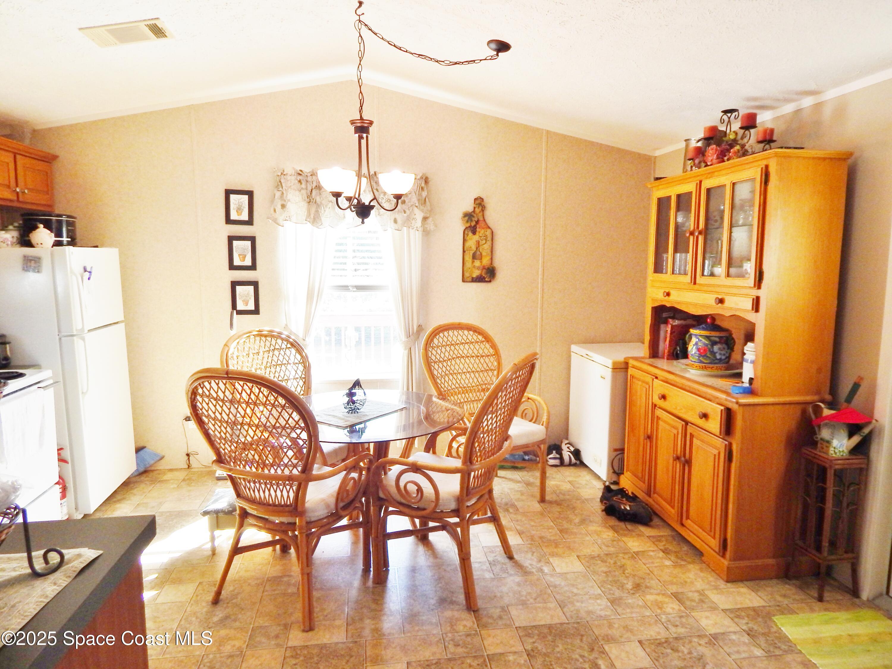 3016 Indian River Drive Northeast Palm Bay, FL 32905 - Photo 15 of 27 a view of a dining room with furniture and a chandelier