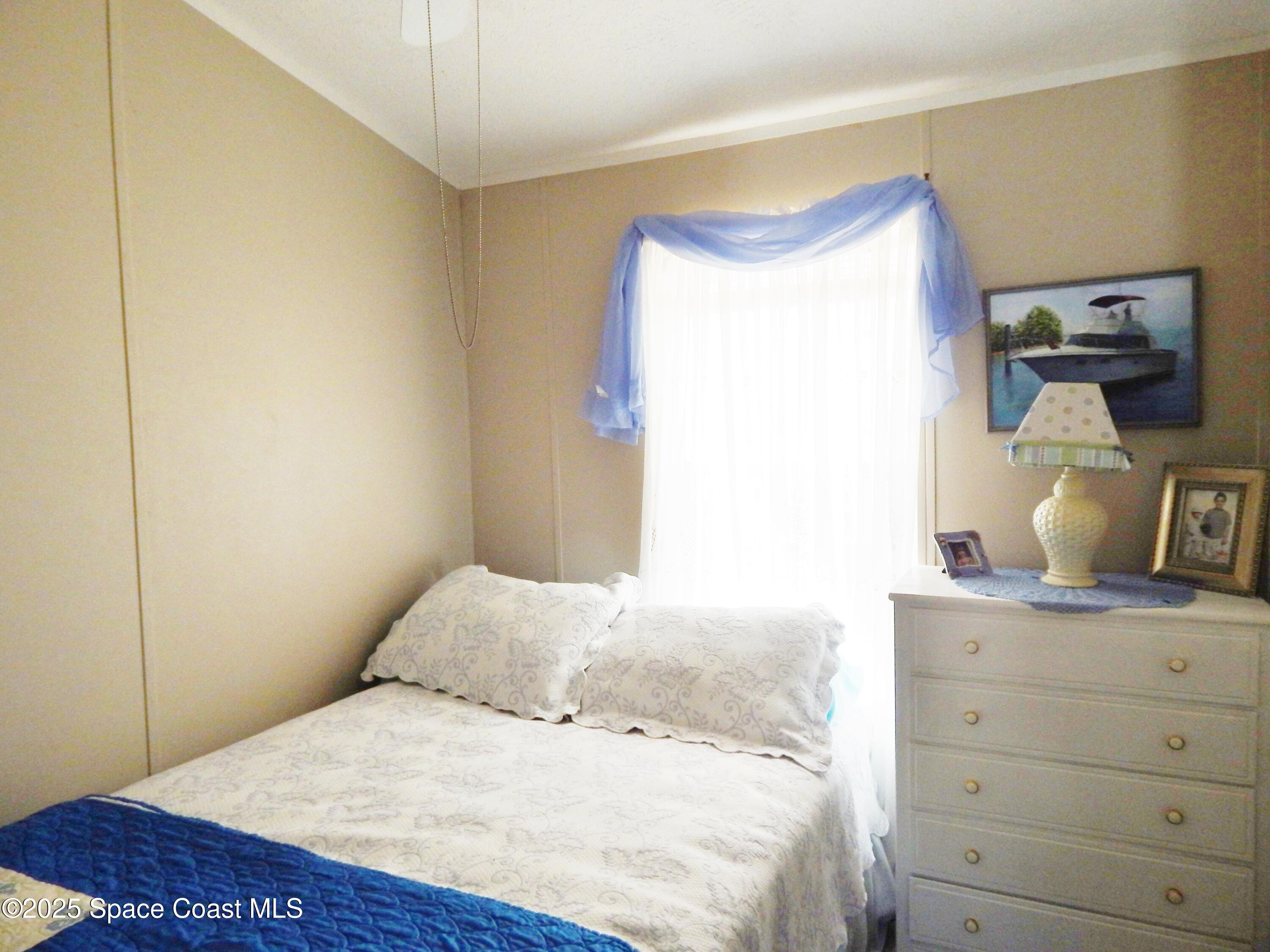 3016 Indian River Drive Northeast Palm Bay, FL 32905 - Photo 17 of 27 a bedroom with a bed and a dresser