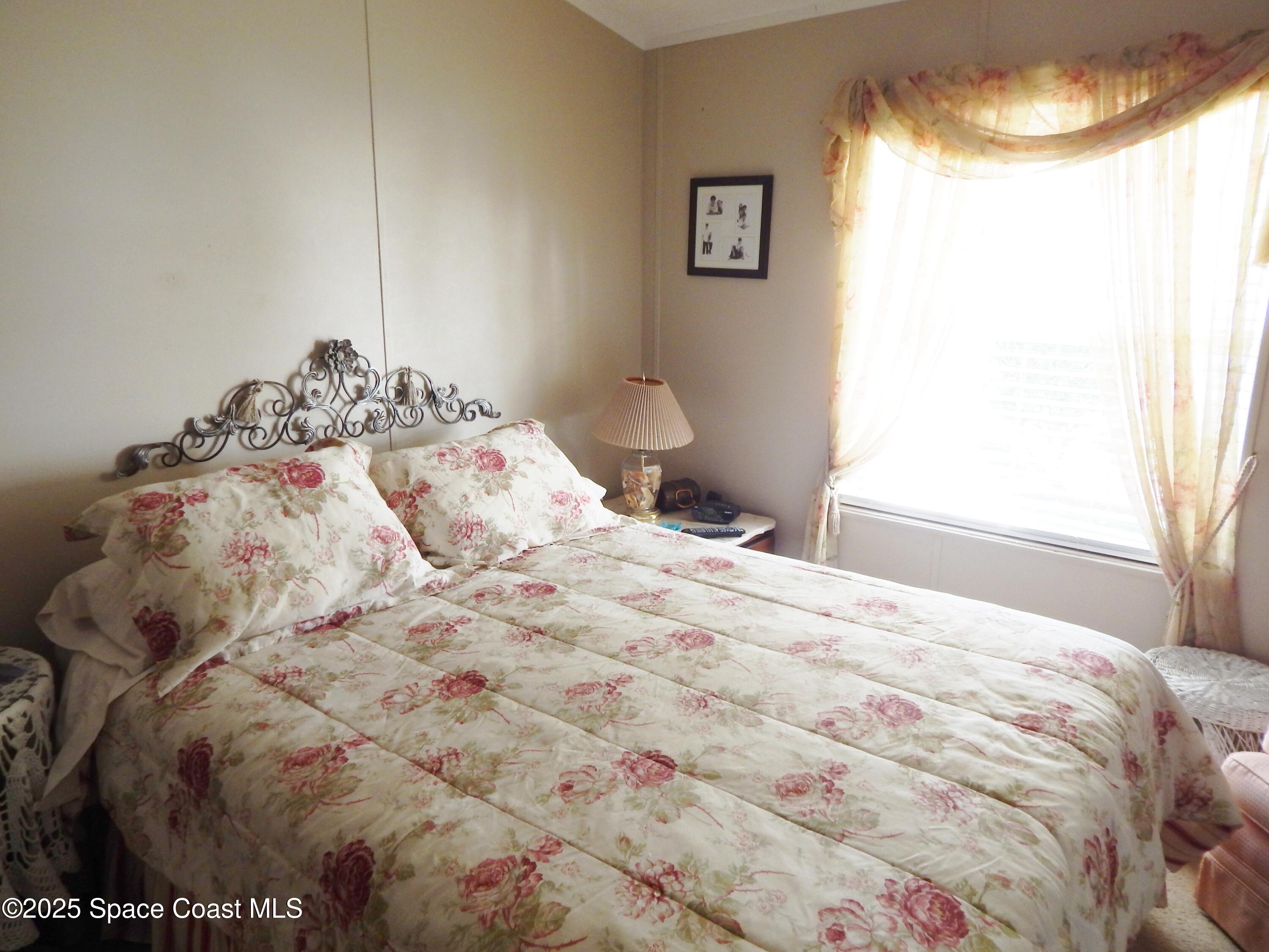 3016 Indian River Drive Northeast Palm Bay, FL 32905 - Photo 20 of 27 a bedroom with a bed and a window
