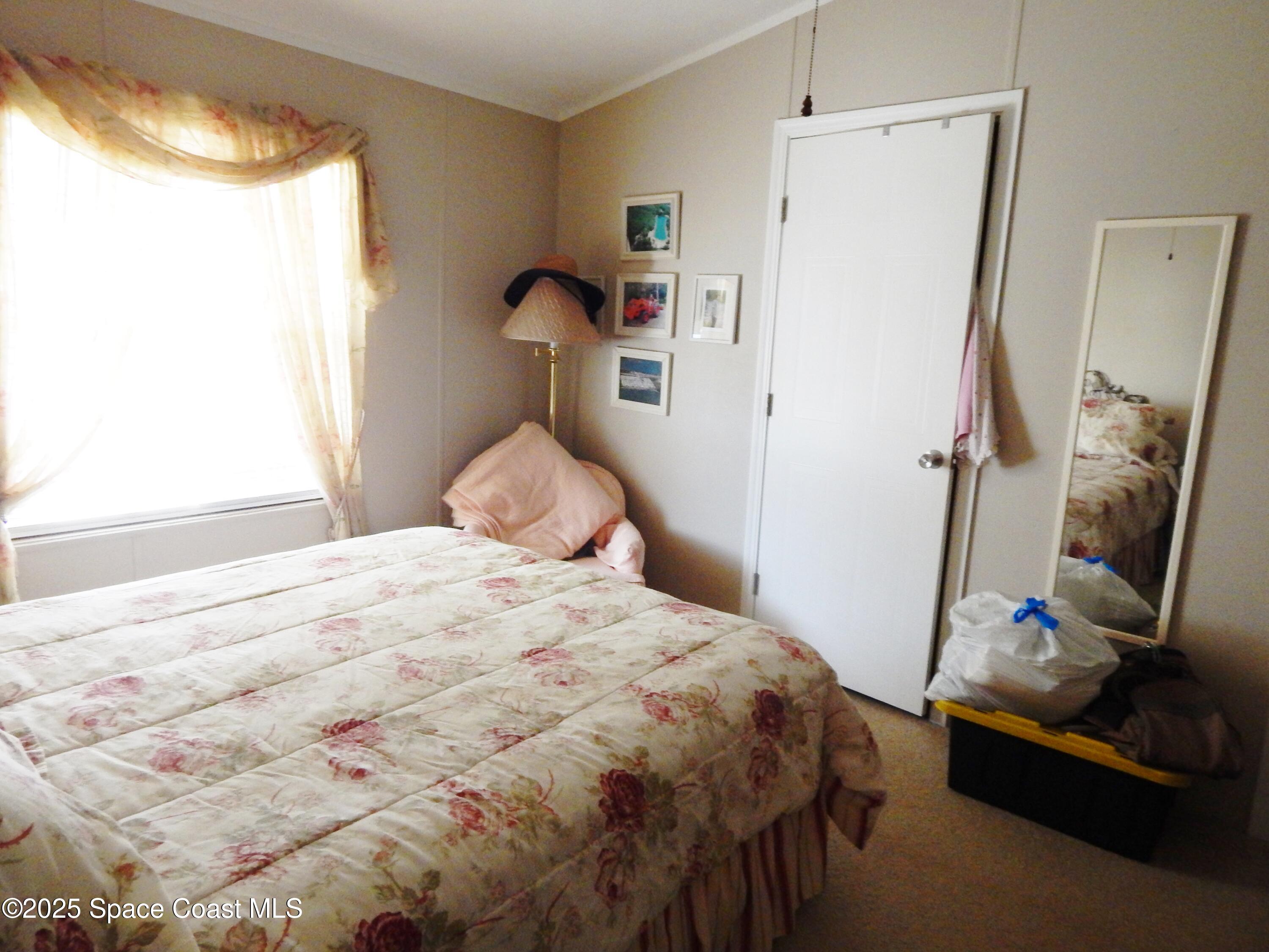 3016 Indian River Drive Northeast Palm Bay, FL 32905 - Photo 22 of 27 a bedroom with a bed and a window