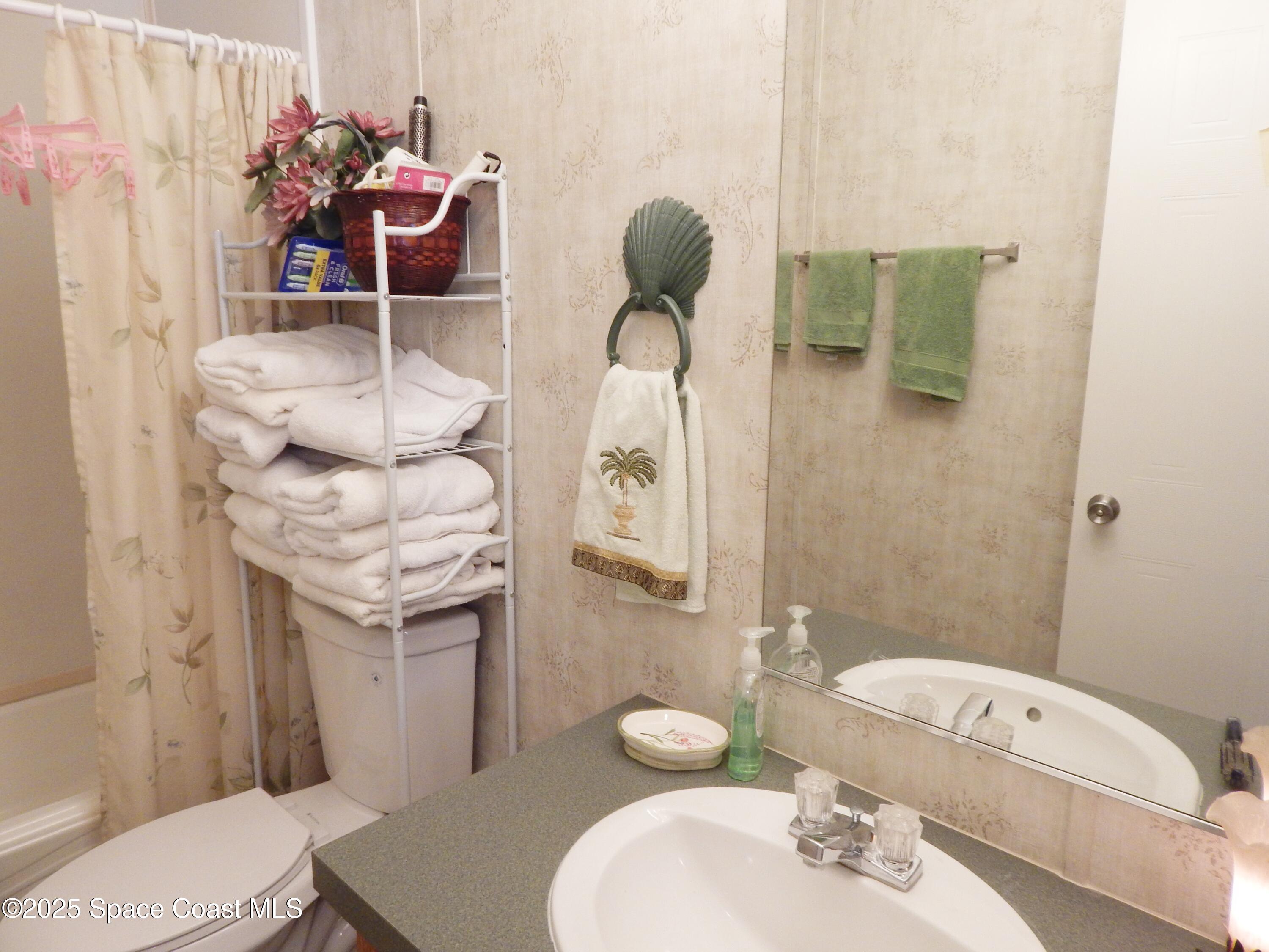 3016 Indian River Drive Northeast Palm Bay, FL 32905 - Photo 24 of 27 a bathroom with a sink a toilet and mirror