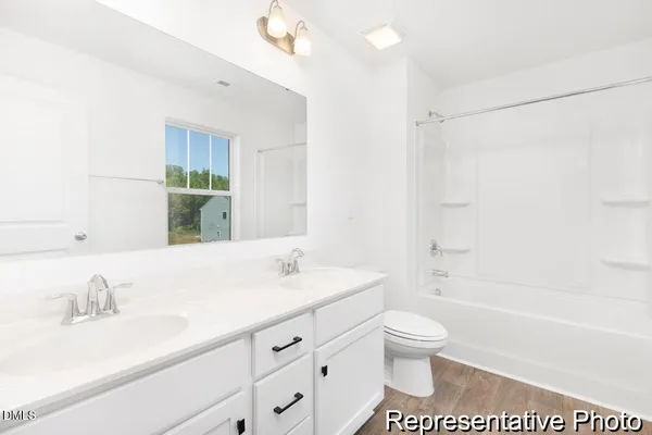 a bathroom with a granite countertop sink a toilet and a bathtub