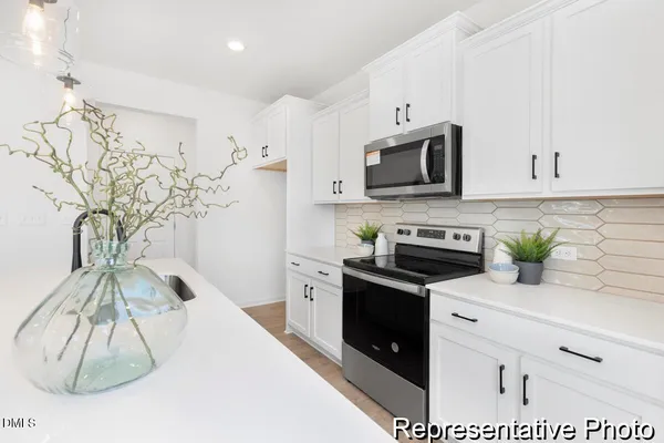 a kitchen with stainless steel appliances granite countertop a stove a microwave and cabinets