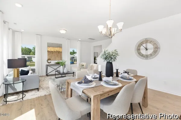 a view of a dining room with furniture a chandelier and wooden floor
