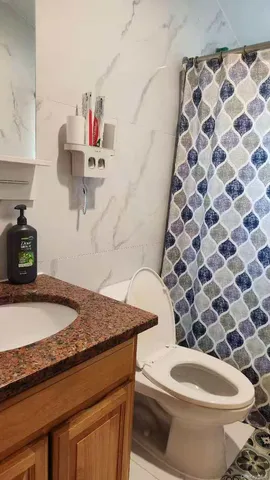 a bathroom with a granite countertop toilet sink and mirror