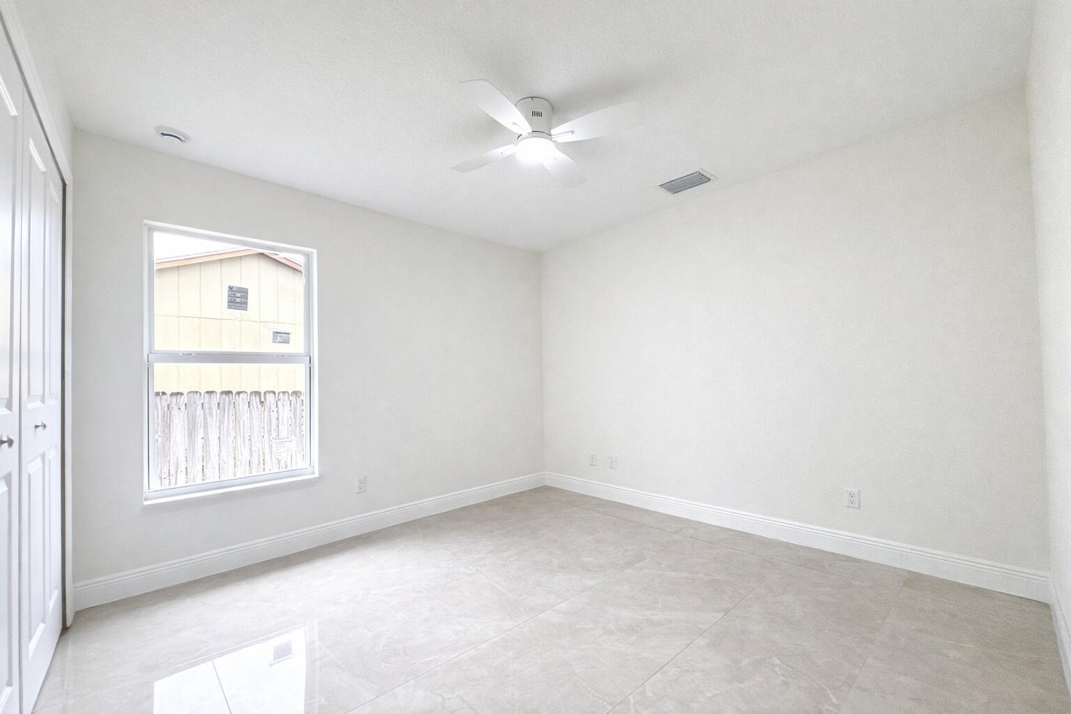 655 Southwest Seagull Terrace Port St. Lucie, FL 34953 - Photo 22 of 24 an empty room with a window and a fan