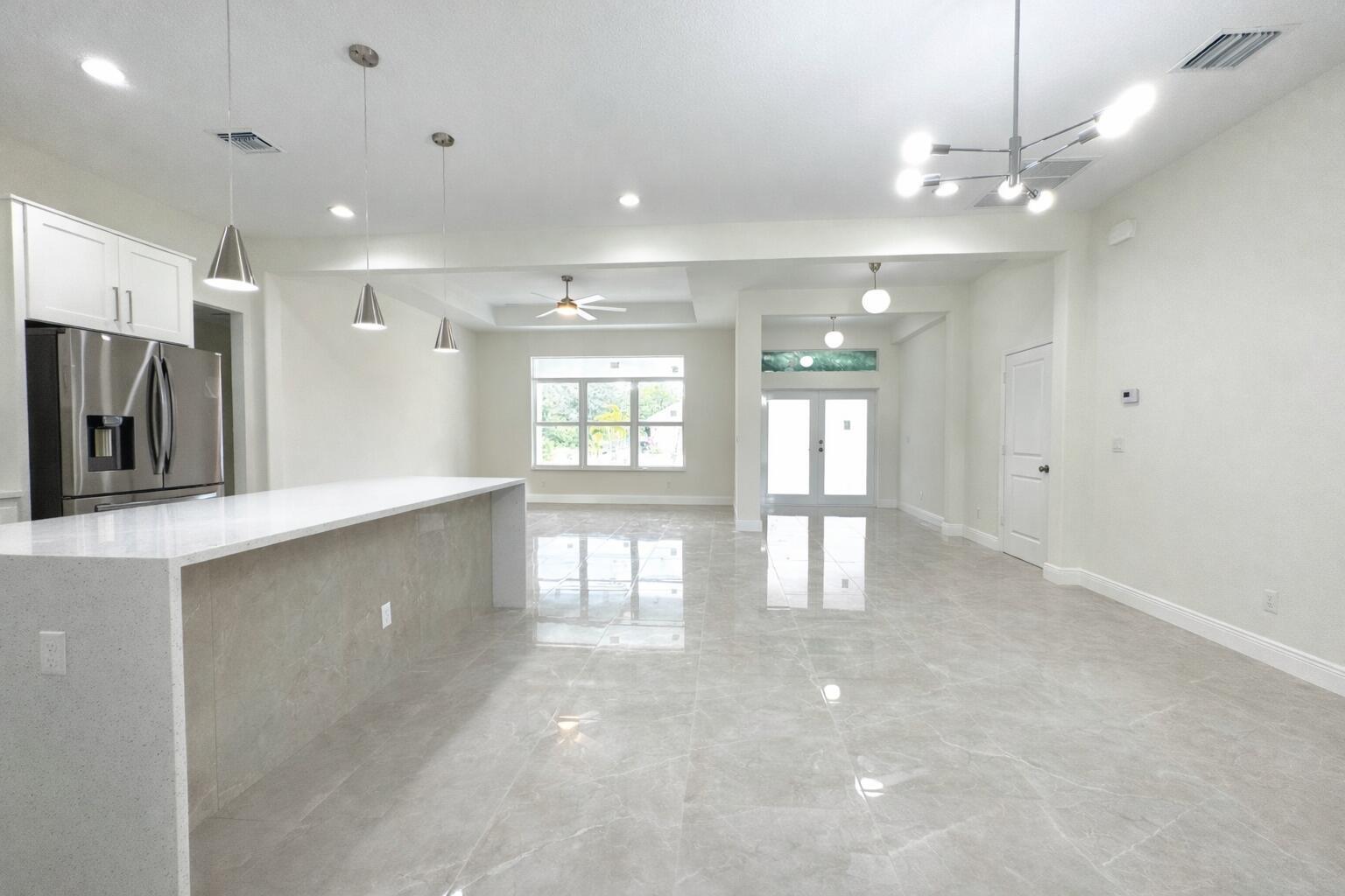655 Southwest Seagull Terrace Port St. Lucie, FL 34953 - Photo 4 of 24 a view of a hallway with windows and chandelier