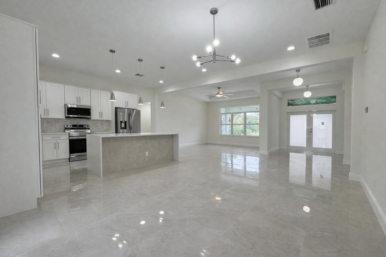655 Southwest Seagull Terrace Port St. Lucie, FL 34953 - Photo 7 of 24 a view of a kitchen with stainless steel appliances refrigerator stove microwave and cabinets